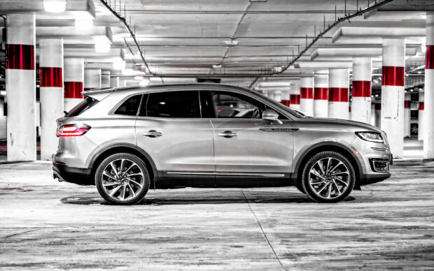 A silver Lincoln Nautilus is parked in an empty underground garage with red and white pillars, 2K Desktop Wallpaper