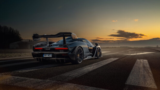 A McLaren Senna is parked on a runway during sunset with dramatic sky in the background, 4K Desktop Wallpaper