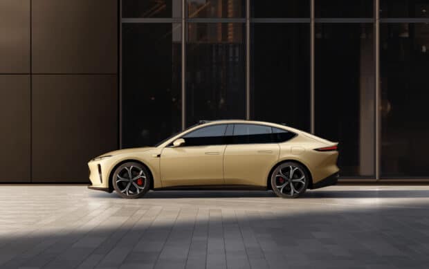 A golden Nio Auto is parked in front of a contemporary building with reflective windows, HD Desktop Wallpaper