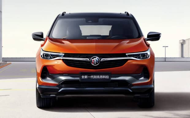 A sleek orange Buick Encore is parked in an open paved area under clear skies, Buick Encore Wallpapers, HD Desktop Wallpaper