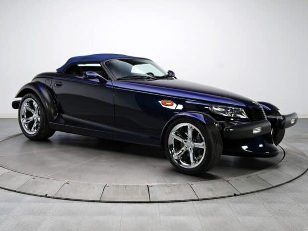 A dark blue Plymouth Prowler sports car is displayed on a gray platform with a white background, HD Desktop Wallpaper