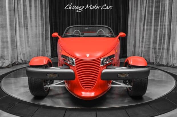 A red Plymouth Prowler is displayed in a showroom with curtains in the background, HD Desktop Wallpaper