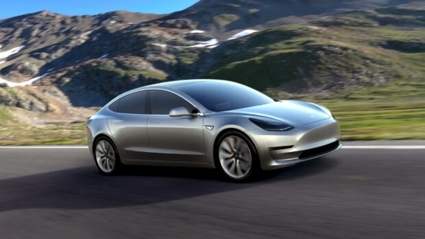 A silver Tesla Model 3 is driving along a winding road with mountains in the background, 2K Desktop Wallpaper