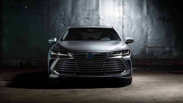 A silver Toyota Avalon is parked in a dark industrial setting with dramatic lighting, 4K Desktop Wallpaper