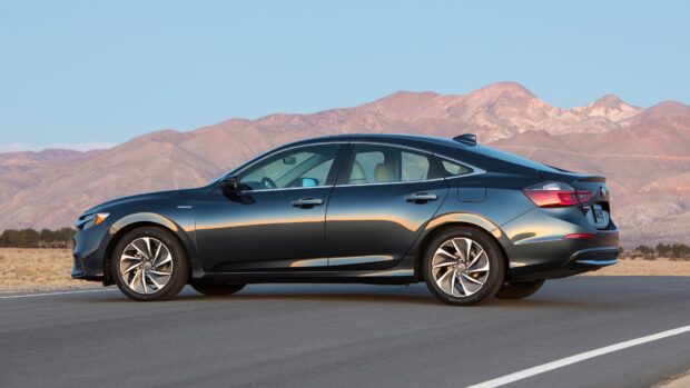 A black Honda Insight is parked on an empty desert road with mountains in the background, 4K Desktop Wallpaper