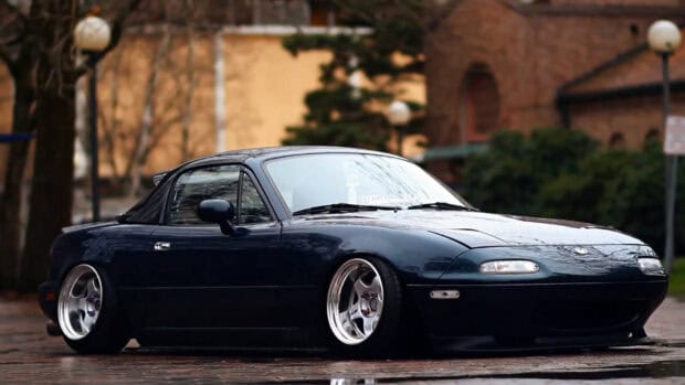 A black Mazda MX 5 Miata is parked on a wet street with reflections, HD Desktop Wallpaper