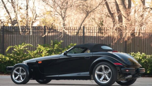 A black Plymouth Prowler is parked outdoors near a fence, HD Desktop Wallpaper