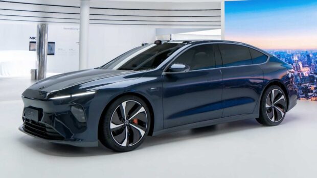 A sleek blue Nio ET7 electric car is displayed in a modern showroom setting, HD Desktop Wallpaper