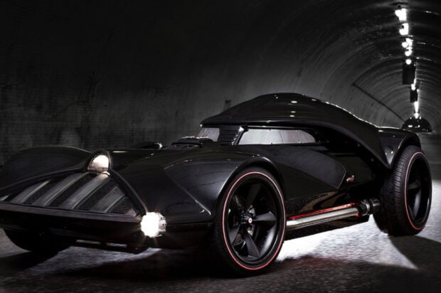 A sleek futuristic black car is parked inside a dimly lit tunnel featuring Hot Wheels Wallpapers, HD Desktop Wallpaper