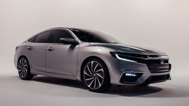 A sleek silver Honda Insight shines under studio lights highlighting its modern design, 4K Desktop Wallpaper