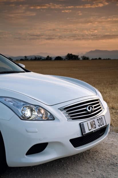 A white Infiniti G37 is parked on a dirt road with a scenic sunset sky in the background, HD Mobile Wallpaper