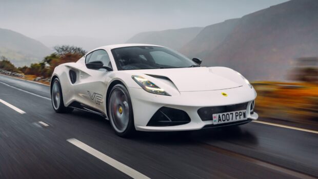 A white Lotus Emira car is driving fast on a wet road with mountainous background, 2K Desktop Wallpaper