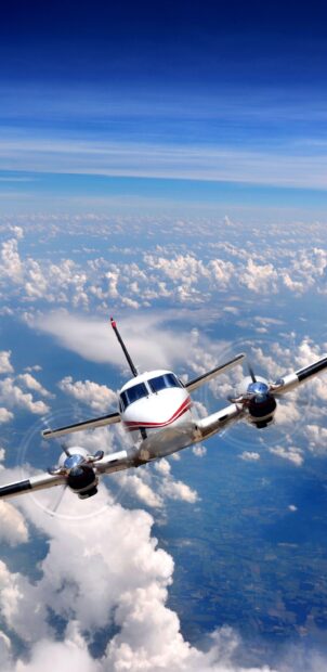A small twin engine aircraft flies high above the clouds with a clear sky, 2K Mobile Wallpaper