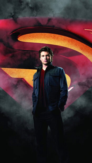 A standing man in front of a dark smoky background with a large Superman emblem behind him, 4K Phone Wallpaper