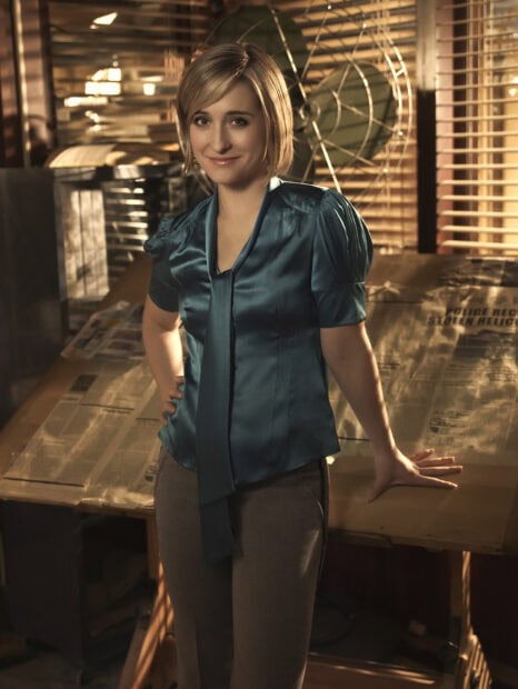A woman poses confidently in a Smallville Tv Series setting with warm lighting, HD Desktop Wallpaper
