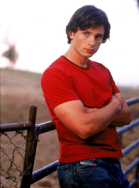 A young man in a red shirt stands by a fence in Smallville Tv Series, HD Desktop Wallpaper
