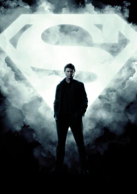 A man stands confidently in front of a glowing symbol in the sky representing Smallville Tv Series wallpapers, 2K Mobile Wallpaper