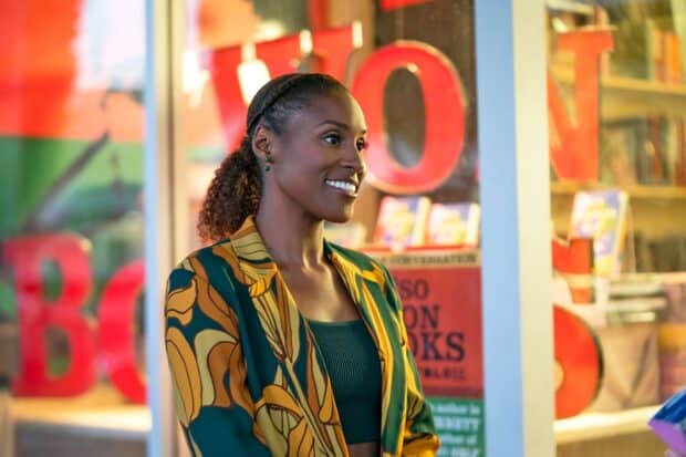 A smiling woman wearing a patterned jacket in a colorful setting from Insecure TV series, HD Desktop Wallpaper