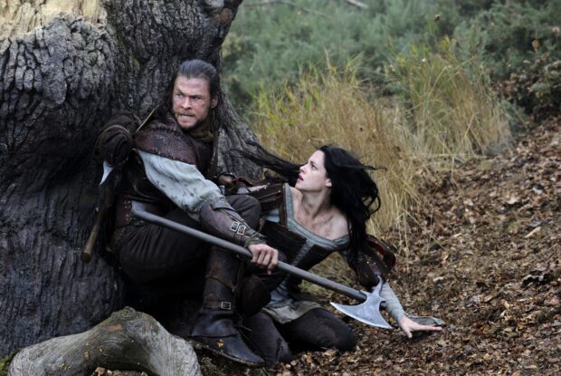 A man and a woman in medieval clothes hiding behind a tree in a tense moment from Snow White And The Huntsman, HD Desktop Wallpaper