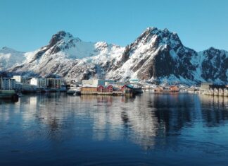 A peaceful village reflects on the water beneath snow capped mountains in the Norwegian fjords, HD Desktop Wallpaper
