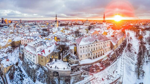 Aerial view of snow covered Old Town in Estonia during sunset with colorful rooftops, HD Desktop Wallpaper