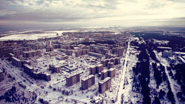 An aerial view shows a ghost town with snow covering the buildings and streets in a vast area, HD Desktop Wallpaper