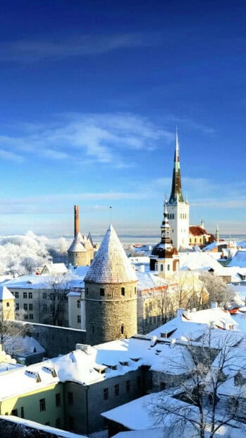 The snow covered old town of Estonia is captured under a clear blue sky, HD Mobile Wallpaper