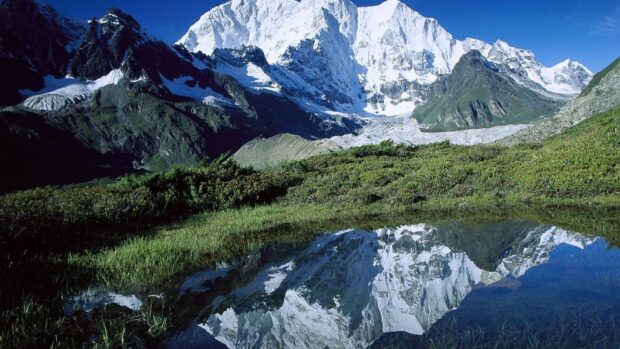 The Tibetan Highlands feature towering snow covered peaks reflected in a clear mountain lake, HD Desktop Wallpaper