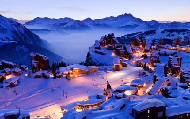 A snowy village illuminated at dusk with mountains in the background is shown in this image featuring village wallpapers, HD Desktop Wallpaper