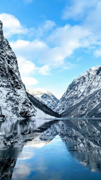 A peaceful glacier landscape with snowy mountains reflected in calm water captured in glacier wallpapers 4K and HD, 2K Phone Wallpaper
