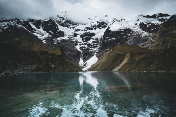 A snowy mountain reflects clearly in the calm lake water in Peru, HD Desktop Wallpaper