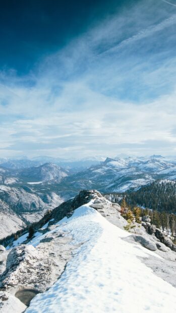 A scenic view of a snowy mountain ridge surrounded by glaciers and distant peaks, 4K Phone Wallpaper