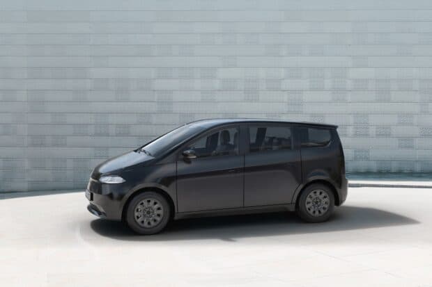 A sleek black Sono Motors vehicle parked by a textured wall, HD Desktop Wallpaper