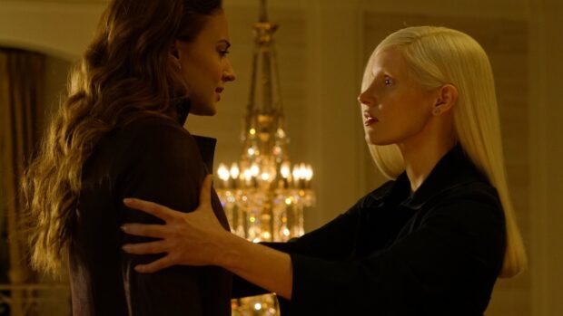 Sophie Turner embracing a woman in a warmly lit room with a chandelier in the background, 4K Desktop Wallpaper