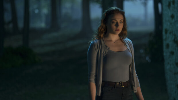 Sophie Turner stands in a dark forest scene looking thoughtful at night, 4K Desktop Wallpaper