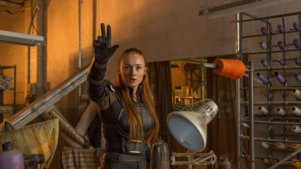 Sophie Turner reaches out wearing a black tactical outfit in an industrial setting, 4K Desktop Wallpaper