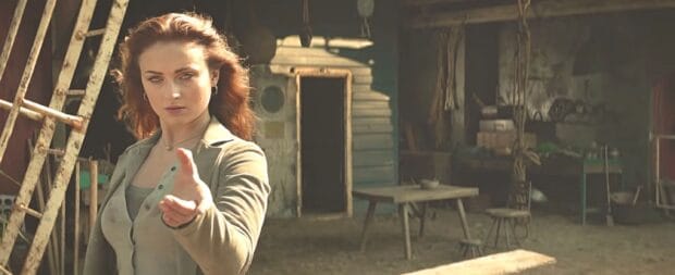 Sophie Turner is pointing forward with a serious look in a rustic setting, 2K Desktop Wallpaper