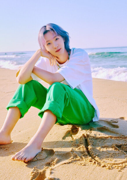 A young person with colorful hair sitting barefoot on the sand near the ocean, HD Phone Wallpaper