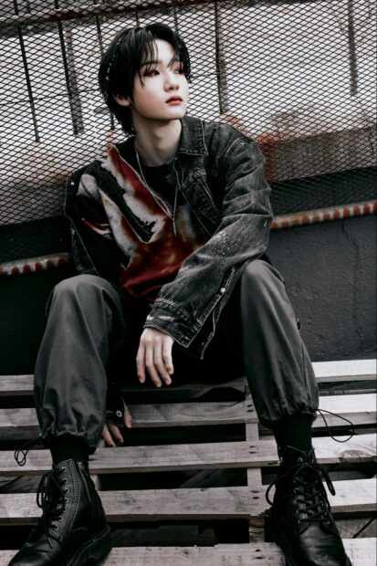 A young man wearing dark clothes leans against a metal fence in a contemplative pose, HD Phone Wallpaper