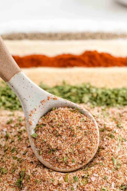 A ceramic spoon holds a colorful seasoning blend with herbs and spices, HD Phone Wallpaper