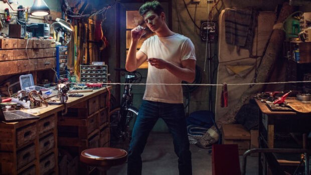 Spider Man Andrew Garfield testing his web shooter in a workshop setting, HD Desktop Wallpaper
