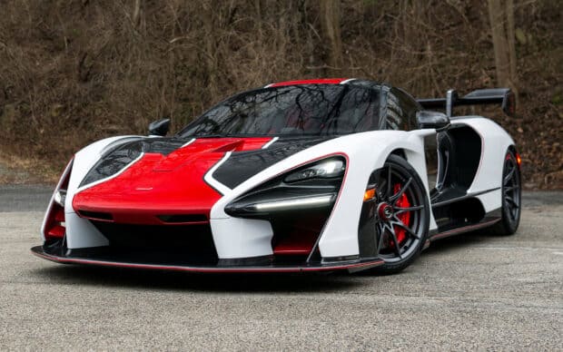 A red and white McLaren Senna is parked on a road surrounded by trees, HD Desktop Wallpaper