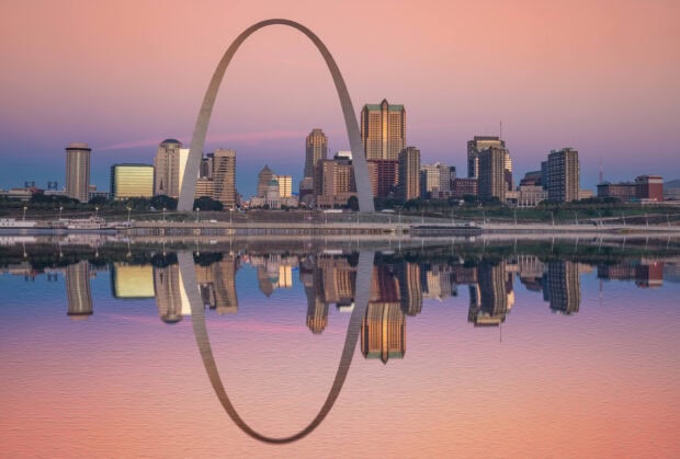 The St Louis skyline is reflected on the calm river with a pink and purple sky, 2K Desktop Wallpaper