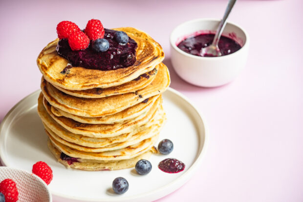 A stack of pancakes with fresh berries and blueberry jam on a white plate, HD Desktop Wallpaper
