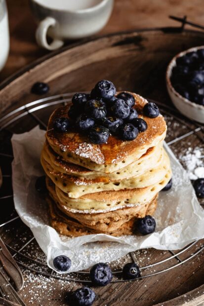 A stack of pancakes topped with fresh blueberries and powdered sugar on a rustic wooden table, HD Phone Wallpaper