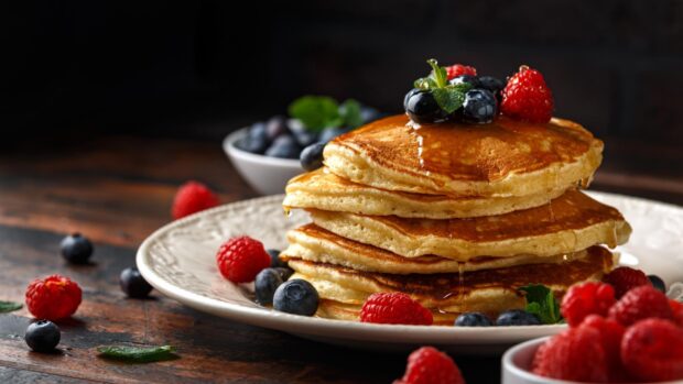 A stack of pancakes topped with fresh berries and syrup on a plate, HD Desktop Wallpaper