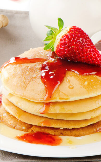 A stack of pancakes topped with a fresh strawberry and syrup dripping down, HD Mobile Wallpaper