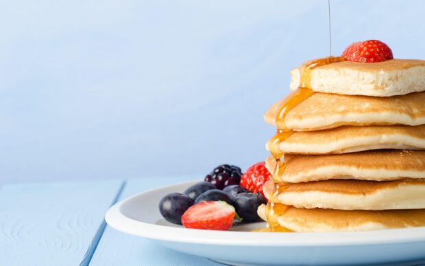A stack of pancakes topped with syrup and strawberries with blueberries on a white plate, 2K Desktop Wallpaper