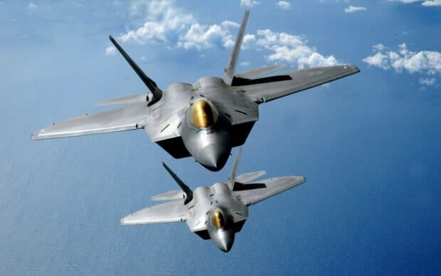 Two jet fighters flying over the ocean with clouds in the background, 2K Desktop Wallpaper
