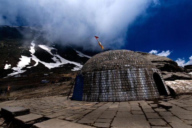 A stone dome structure stands under a cloudy sky in the Tibetan highlands, 2K Desktop Wallpaper